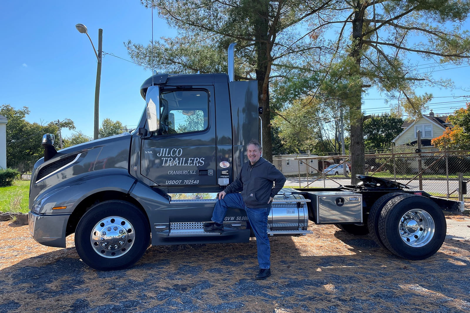 A member of the Jilco team standing beside a Jilco-branded truck cab at the company's New Jersey facility.